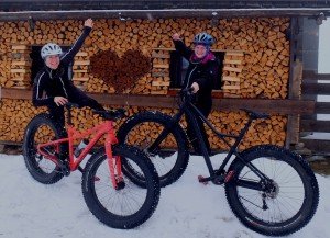 Mädels mit zwei Fatbikes vor einer Hütte